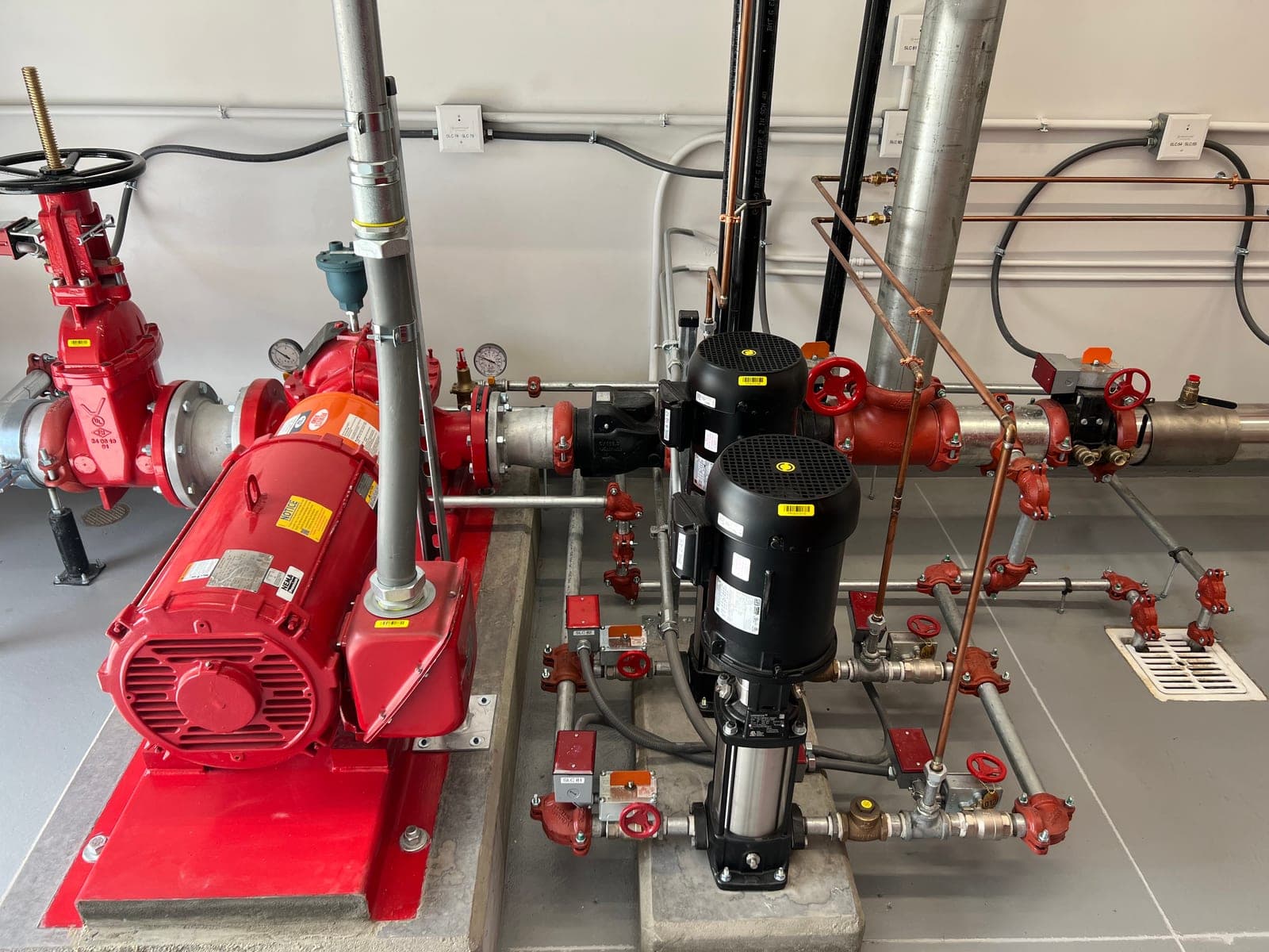 Red horizontal split-case fire pump and vertical jockey pump in a clean Myers AFP fire pump room installation in Kansas