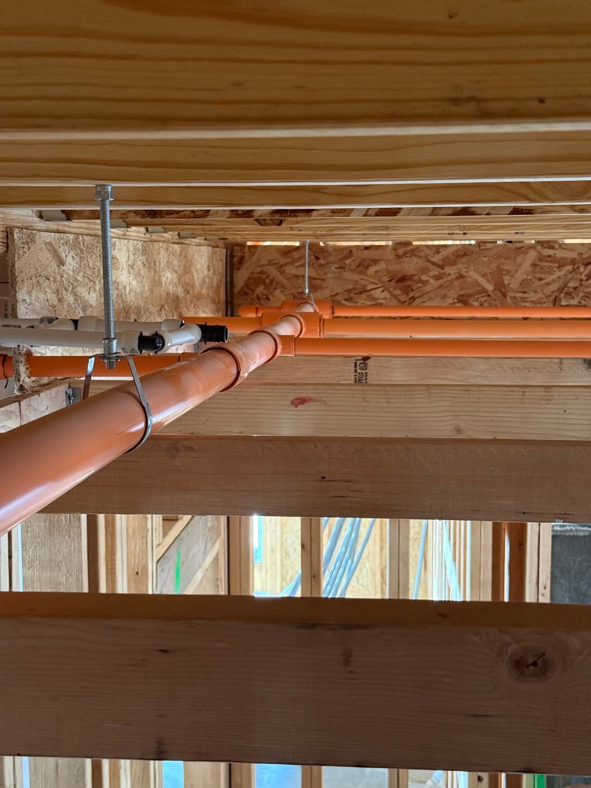 Residential fire sprinkler piping installed through the wood floor joists of a Kansas home by Myers AFP